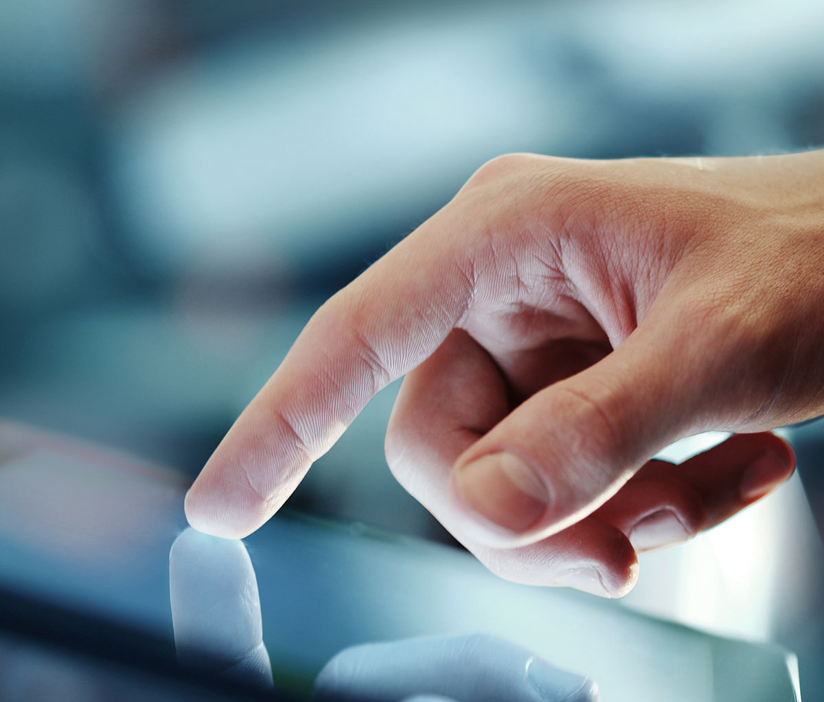 A photo of a hand touching a screen.
